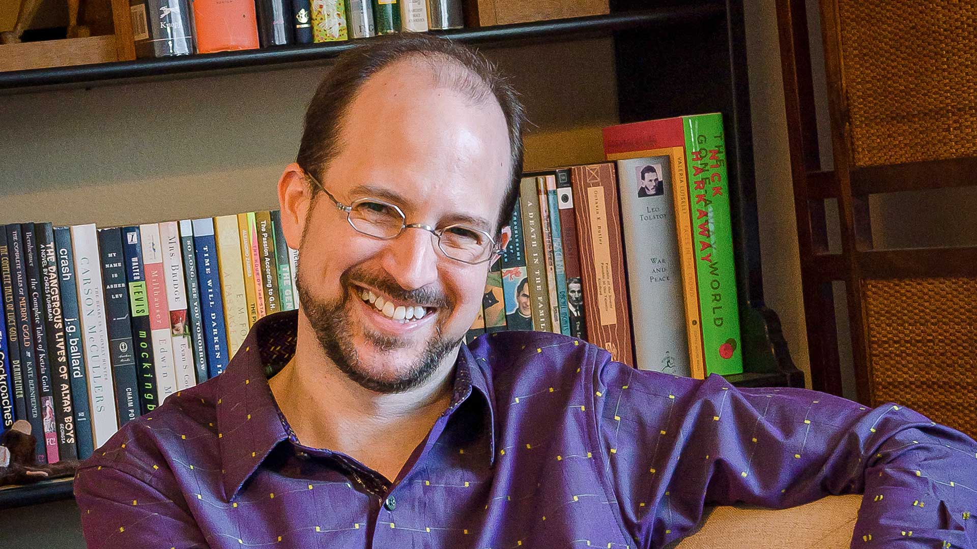 Kevin Brockmeier sitting in front of a bookshelf